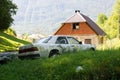 Neglected car in front of a unfinished house