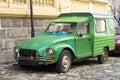 Neglected green pickup oldtimer parked in the old cobble stone street