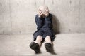 Neglected lonely child leaning at the wall Royalty Free Stock Photo