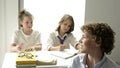 Negligent student interferes with classmates. Boy is bored in the lesson.