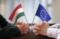 Negotiation between Hungary and European Union. Hungarian and Europen flags in background