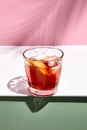 Negroni cocktail over pink background. Drink in rox glass in daylight with palm leaf hard shadow. Summer, tropical, fresh drink Royalty Free Stock Photo