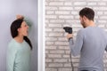 Neighbor Man Using Power Drill On Brick Wall