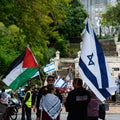 Nelson, New Zealand, 3rd February 2024, Two protestors, one carrying a Palestinian flag, the other with an Israeli flag stand Royalty Free Stock Photo