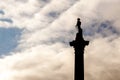 Nelson`s column silhouette in Trafalgar Square, London against a cloudy sky at dusk Royalty Free Stock Photo