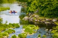 People kayaking along mountain river in spring. Extreme sport participants