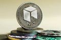 neo coin dominates the background of multicolored coins of different cryptocurrencies on a light background Royalty Free Stock Photo