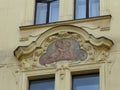 Neoclassic style painting below windows of an ancient building to Prague in Czech Republic.