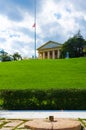 A building on grassy hill at Arlington Cemetery with USA flag at half-mast Royalty Free Stock Photo