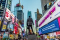 Neon advertising of News, brands and theaters at times square with statue of George M. Cohan in early morning