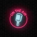 Neon on the air sign with retro microphone in round frame. Nightclub with live music icon. Royalty Free Stock Photo