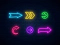 Neon arrow signs collection. Bright arrow pointer symbols on brick wall background Royalty Free Stock Photo