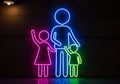 Neon artwork featuring a stylized family of three outlined on a dark background. The figures are Royalty Free Stock Photo