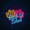 Neon banner with back to school greeting text. Glowing neon sign with maple leaves. Design of leaflet, flyer.