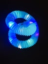neon blue corrugated tube in the form of shapeless bends on a black background