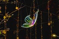 Neon butterfly among Christmas garlands on the background of the black sky