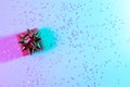 Neon Christmas winter background. Xmas gift box with shine lights. Holiday decoration on neon abstract gradient backdrop Royalty Free Stock Photo