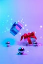 Neon Christmas winter background. Xmas gift box with shine lights. Holiday gifts, decoration bauble ball on neon Royalty Free Stock Photo