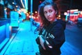 Neon close up portrait of young woman wear hoodie. night city street shot