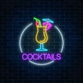 Neon cocktail glass sign in circle frame on dark brick wall background. Glowing gas advertising with alcohol shake. Royalty Free Stock Photo