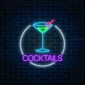 Neon cocktail sign in circle frame on dark brick wall background. Glowing gas advertising with glass of alcohol shake. Royalty Free Stock Photo