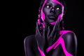 Neon colors. Pink and black body paint. Woman with face art. Young girl with colorful bodypaint. An amazing afro