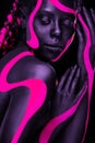 Neon colors. Pink and black body paint. Woman with face art. Young girl with colorful bodypaint. An amazing afro Royalty Free Stock Photo