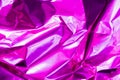 Neon crumpled holographic abstraction in bright pink and purple, selective focus, blur