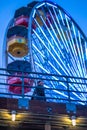 Neon Ferris wheel over an absent minded passer-by