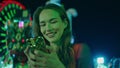 Neon girl messaging smartphone closeup. Smiling attractive teen texting online