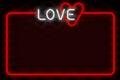 Neon glowing inscription love with frame on black background. Valentine`s day celebration concept