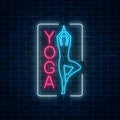 Neon glowing sign of yoga exercices in rectangle frame on dark brick wall background.