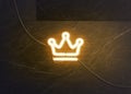 Neon gold crown on dark marble wall, glowing font mockup