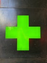 Neon green cross glowing in metal wall of pharmacy Royalty Free Stock Photo