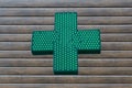 Neon green cross sign on wooden background Royalty Free Stock Photo