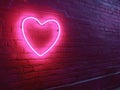Neon heart shaped light on brick wall for modern art and interior decoration Royalty Free Stock Photo