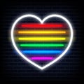 Neon heart sign glow. LGBT pride or Rainbow colors design heart shape in neon lighting style on brick wall background. Royalty Free Stock Photo