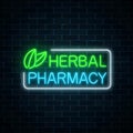 Neon herbal pharmacy sign on dark brick wall background. 100 percent natural medicaments store. Royalty Free Stock Photo