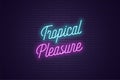 Neon lettering of Tropical Pleasure. Glowing text