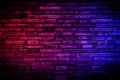 Neon light on brick walls that are not plastered background and texture. Lighting effect red and blue neon background vertical of Royalty Free Stock Photo