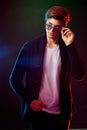 Neon light portrait of handsome male model with dark medium length hair, hairstyle, wear sunglasses Royalty Free Stock Photo