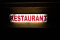 Neon light on a wall showing Restaurant text