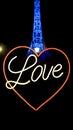 Neon lights of word Love with heart symbol and the Melbourne Arts Centre Spire illuminated in blue