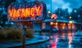 Neon-lit VACANCY sign in bold 3D letters on a reflective blue surface indicating available employment opportunities or Royalty Free Stock Photo