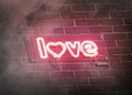 Neon love symbol on dark brick wall mockup with smoke
