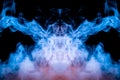 Neon mystical ghostly pattern of blue smoke on a black background depicting several abstract images - the head of aliens from a