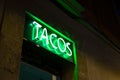 Neon panel with the word Tacos written in green