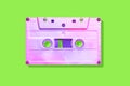 Neon pink cassette tape on a green background with shadow