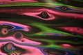 Neon pink and green float in hazy clouds amidst black in this abstract background.