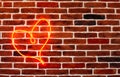 Neon red heart on the brick wall. Romantic grunge backdrop. Royalty Free Stock Photo